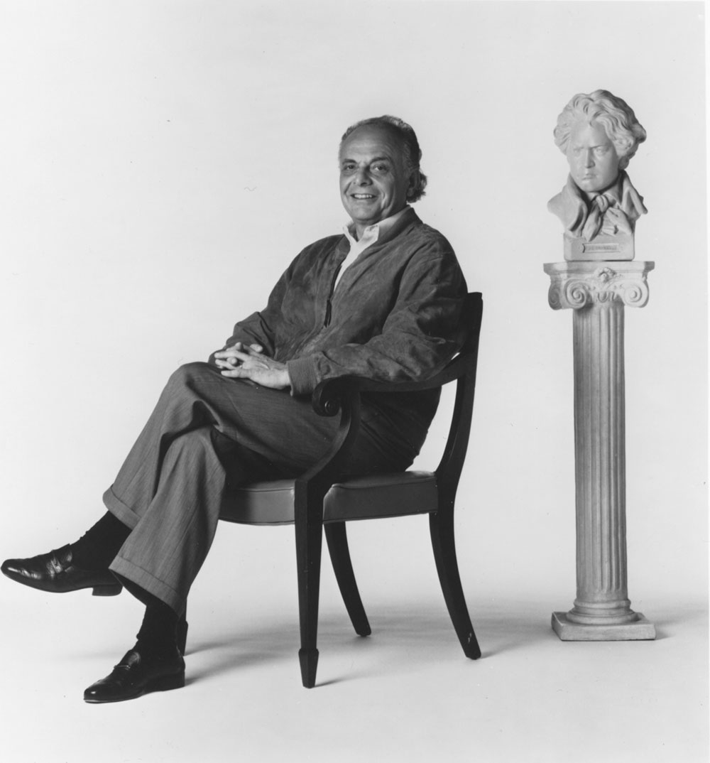 Maazel is seated and smiling at the camera while behind him, to the left, is a bust of Beethoven.