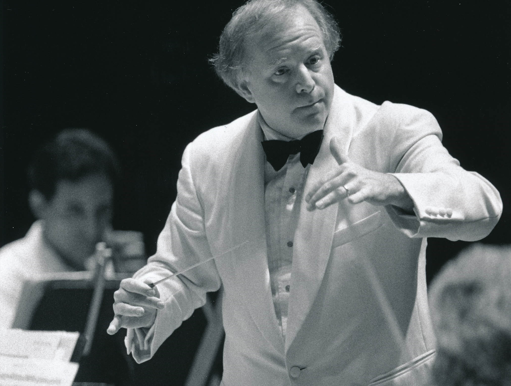 Leonard Slatkin conducting the Orchestra at Blossom Music Center. Slatkin and the Orchestra are dressed in white, which is formal dress for Blossom performances.