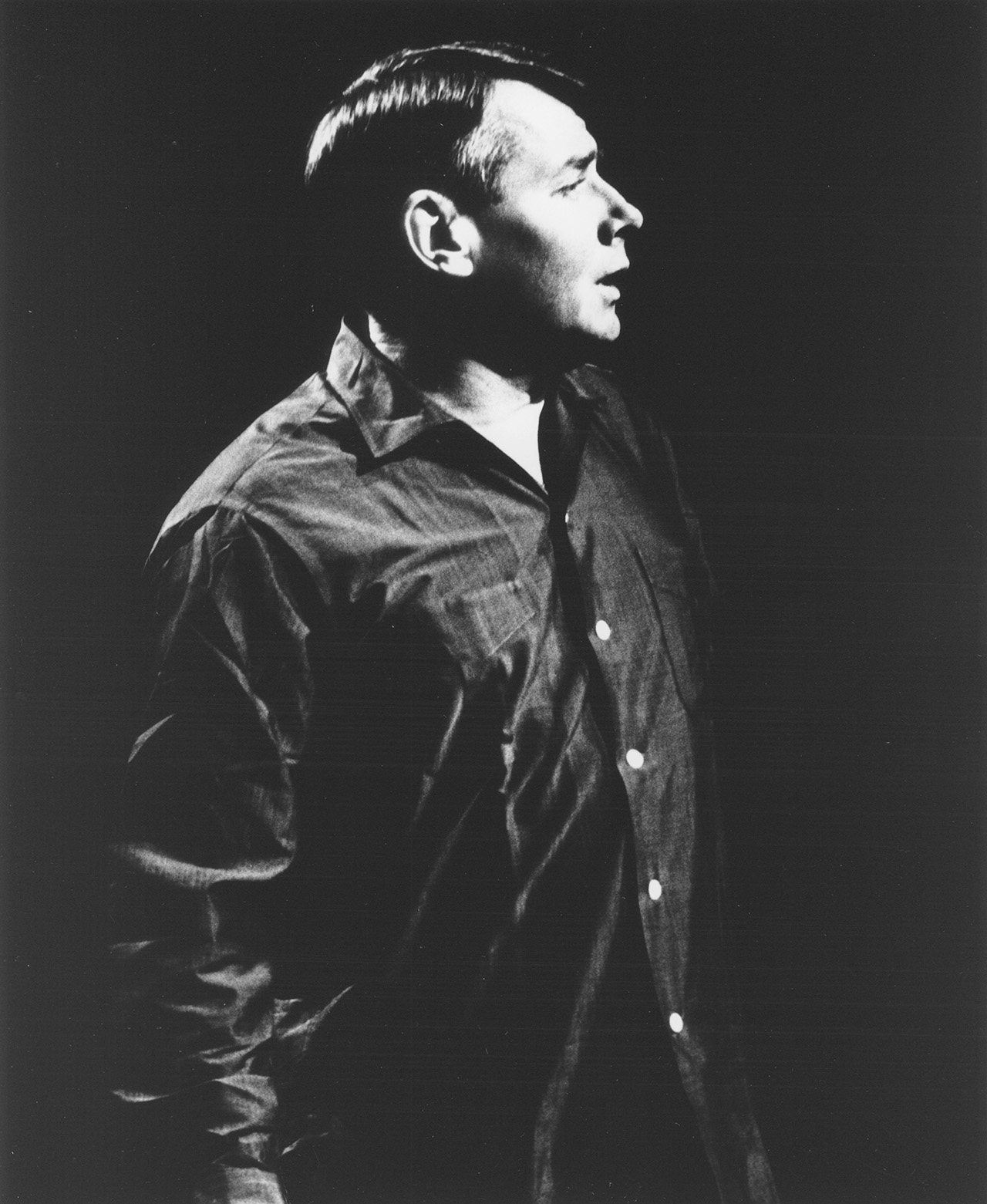 A man in a dark shirt in profile, facing toward his left.