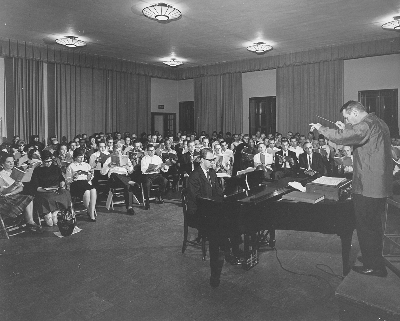 A man conducts a seated choir.