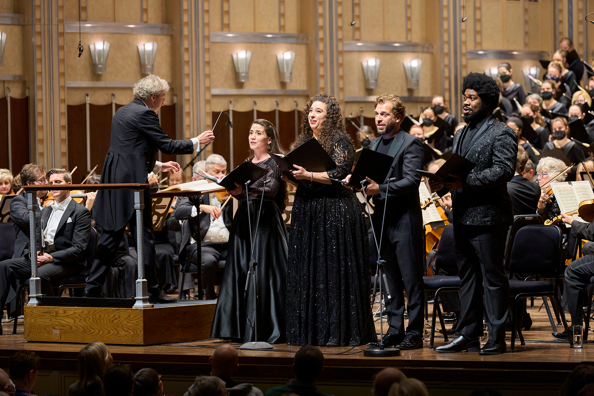 Four singers perform in front of the Orchestra